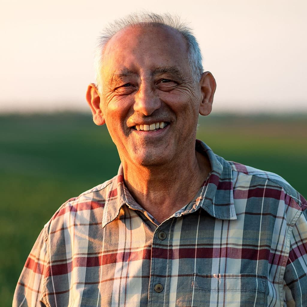 senior farmer standing in wheat field